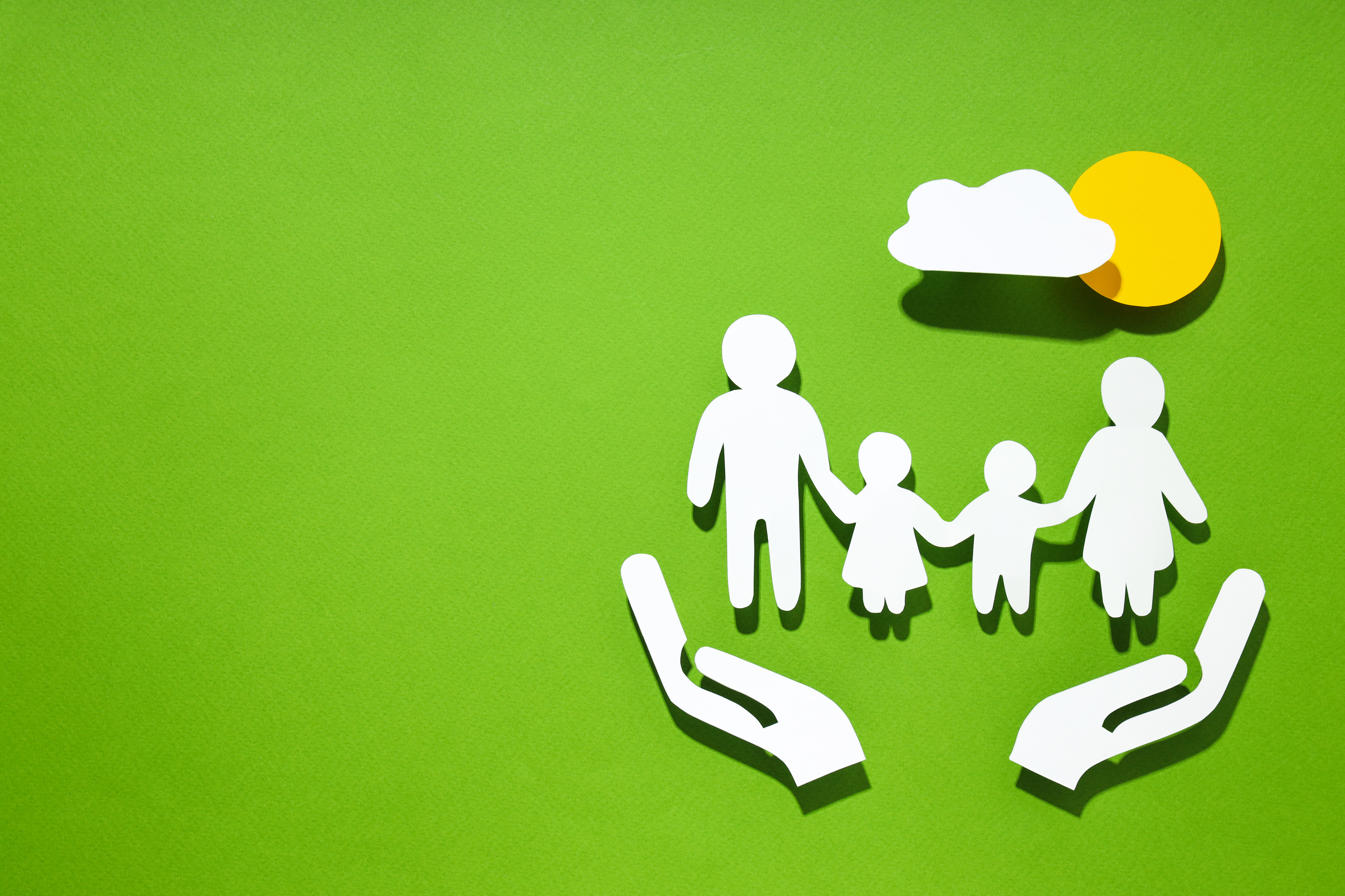 Paper-cutout family protected by hands — risk and life cover planning